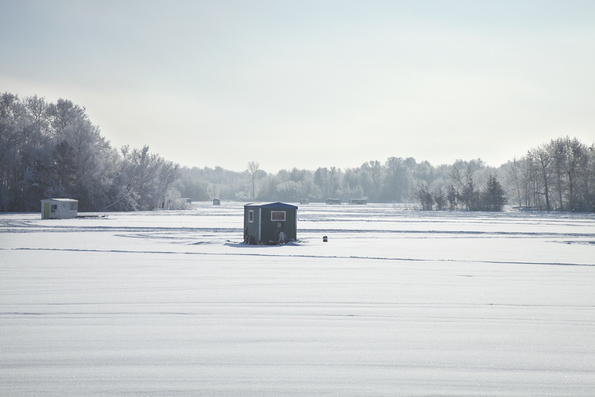 Ice fishing shacks at Minnesota lake on a bright winter morning